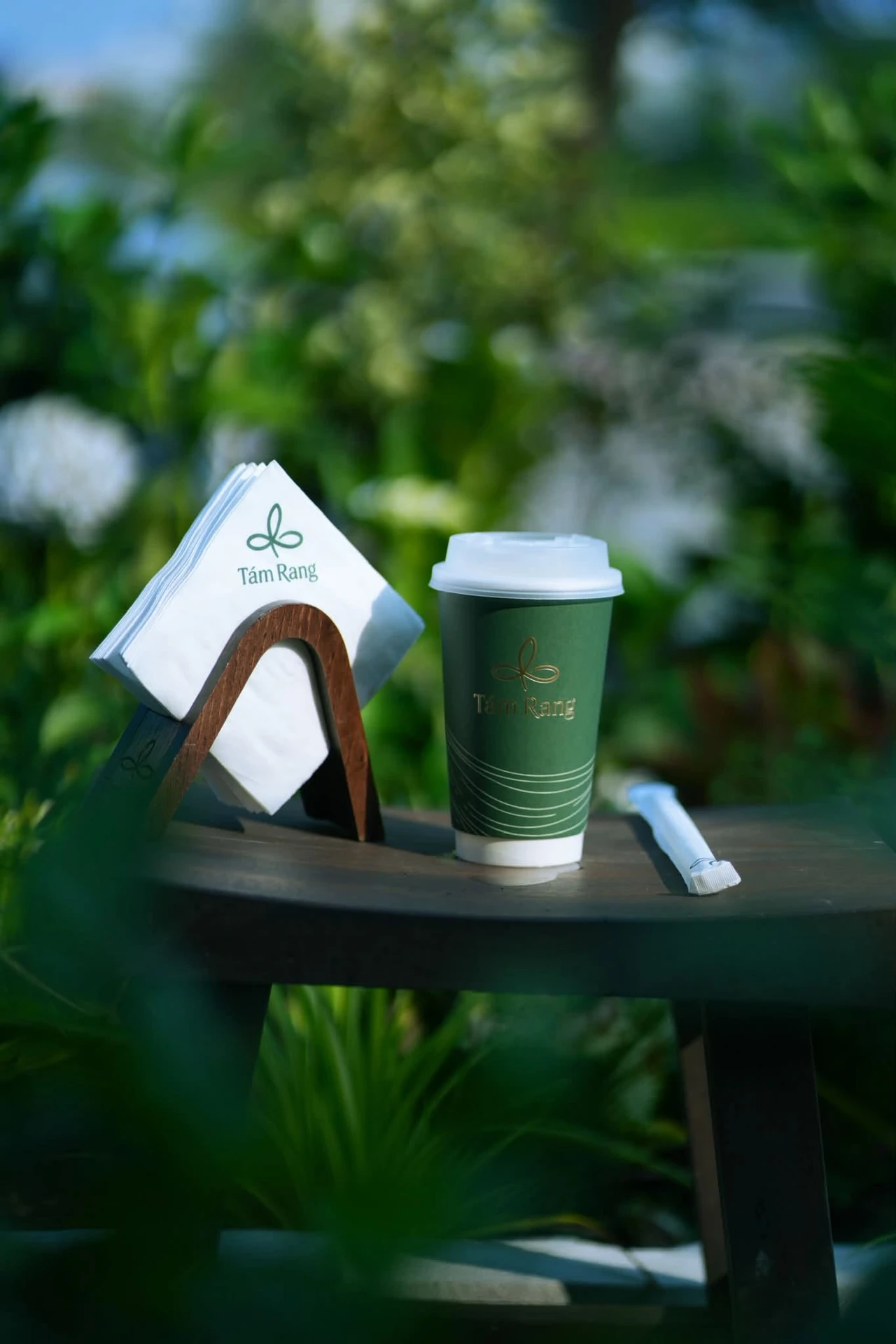Cốc giấy Tám Rang cùng khăn giấy trên bàn giữa khu vườn